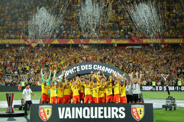 Les joueurs de Lens célèbrent leur titre dans le Trophée des champions après leur victoire 1-0 contre le Paris SG, sur la pelouse de leur stade Bollaert le 16 août 2026 ( AFP / GEOFFROY VAN DER HASSELT )