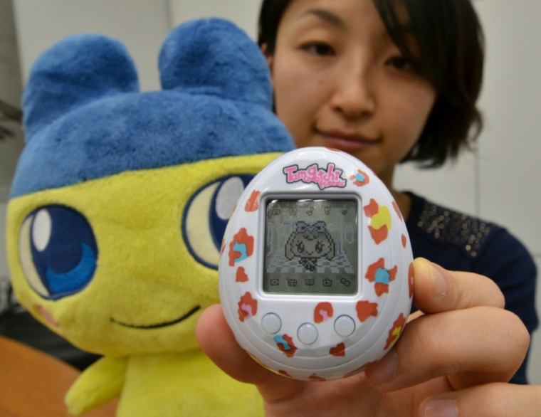 Une employée du groupe japonais Bandai présente un nouveau Tamagotchi le 27 novembre 2013 à Tokyo ( AFP / YOSHIKAZU TSUNO )