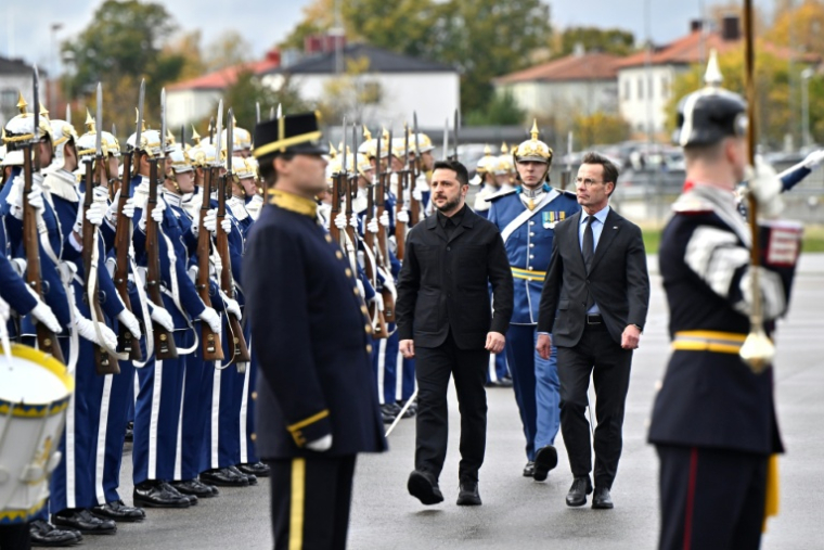 Le Premier ministre suédois Ulf Kristersson (c,d) et le président ukrainien Volodymyr Zelensky passent en revue la garde d'honneur à l'aéroport de Linköping, le 22 octobre 2025 en Suède ( TT News Agency / Christine Olsson/TT )