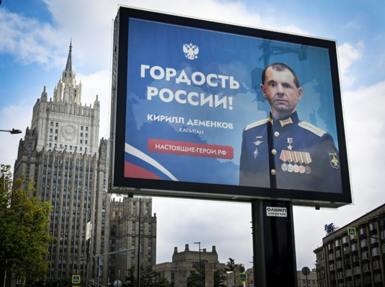 Une affiche sur laquelle on peut lire "La fierté de la Russie" présentant un capitaine de l'armée russe participant à l'offensive en Ukraine, à Moscou le 22 juillet 2025 ( AFP / Alexander NEMENOV )