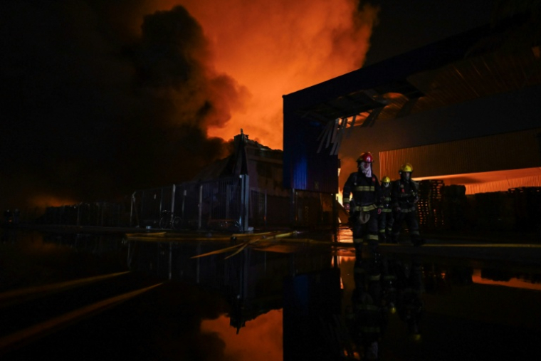 Des pompiers tentent d’éteindre un incendie après une explosion dans une zone industrielle d’Ezeiza, dans la province de Buenos Aires, en Argentine, le 15 novembre 2025. ( AFP / Luis ROBAYO )