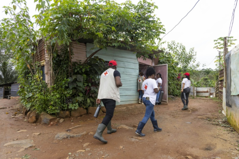 Des membres de la Croix-Rouge viennent à la rencontre des habitants de Savane, un quartier de Matoury, en périphérie de Cayenne, pour les aider à traiter l'eau à domicile, le 6 juin 2026  ( AFP / Ronan LIÉTAR )