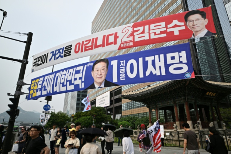 Des banderoles montrant Kim Moon-soo, le candidat à la présidence du Parti du Pouvoir au peuple (en haut, en rouge), et Lee Jae-myung, le candidat à la présidence du Parti démocrate (en bleu), quelques jours avant l'élection présidentielle du 3 juin à Séoul, le 31 mai 2025 ( AFP / Pedro PARDO )