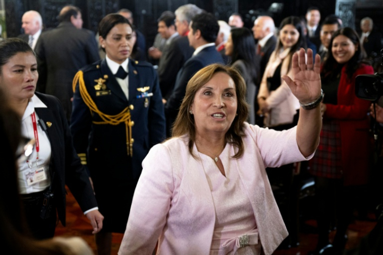 La présidente du Pérou, Dina Boluarte, salue la presse après une cérémonie de promulgation d'une loi d'amnistie pour les militaires et policiers poursuivis pour violations des droits humains, le 13 août 2025 au palais du gouvernement à Lima ( AFP / Ernesto Benavides )