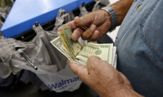 Un client compte son argent à la caisse d'un magasin Walmart dans le quartier de Porter Ranch à Los Angeles.