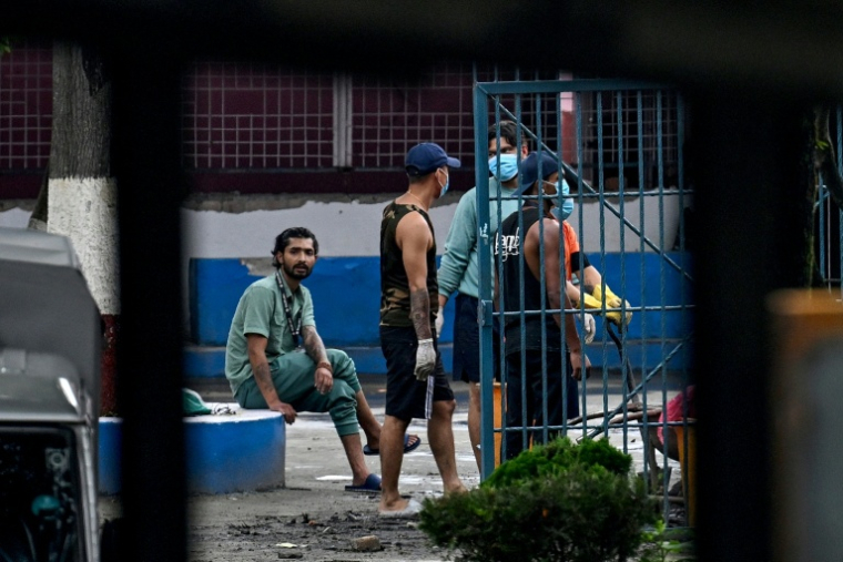 Des volontaires prennent part à l'évacuation des résidus d'incendie à la prison de Katmandou, le 16 septembre 2025 ( AFP / Arun SANKAR )