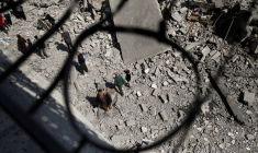 Des Palestiniens inspectent le site d'une frappe israélienne sur un immeuble résidentiel à Jabalia