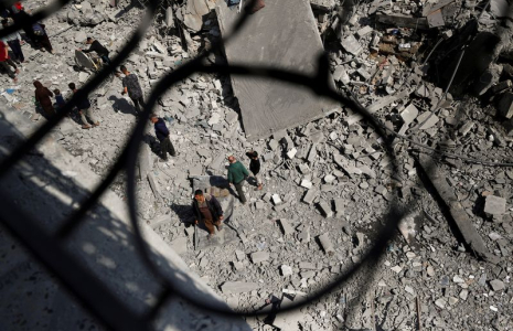 Des Palestiniens inspectent le site d'une frappe israélienne sur un immeuble résidentiel à Jabalia