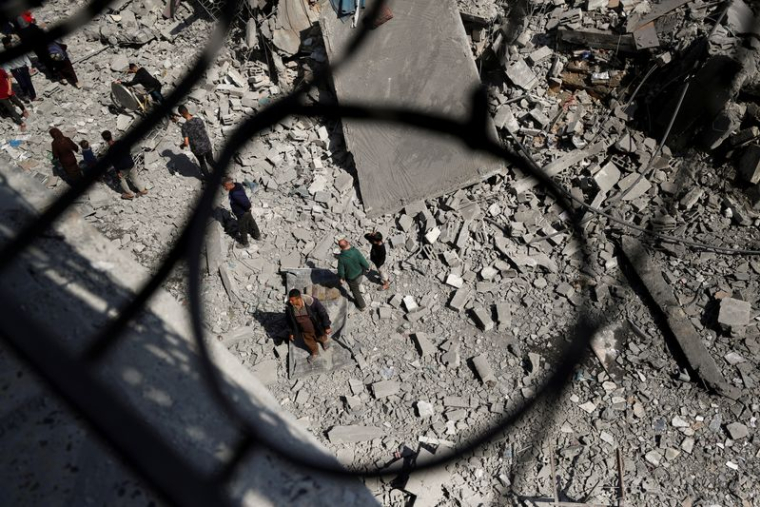 Des Palestiniens inspectent le site d'une frappe israélienne sur un immeuble résidentiel à Jabalia