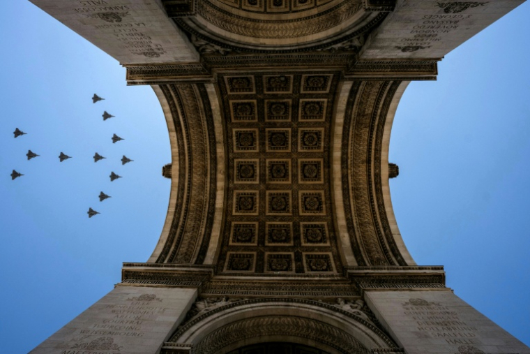 Des avions de chasse Rafale survolent l'Arc de Triomphe lors d'une répétition avant le défilé du 14 Juillet sur l'avenue des Champs-Élysées, à Paris, le 9 juillet 2026 ( AFP / Dimitar DILKOFF )