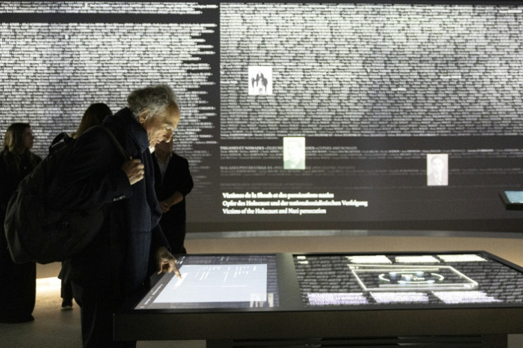 Un visiteur utilise une borne interactive pour afficher un nom devant le "Mur des Noms" dédié aux Alsaciens et Mosellans morts durant la Seconde Guerre mondiale à Schirmeck, le 24 septembre 2026 dans le Bas-Rhin ( AFP / ROMEO BOETZLE )