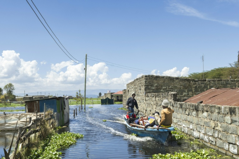 Un bateau transporte un homme contraint par la montée des eaux d'évacuer avec ses biens son quartier des bords du lac Naivasha, dans le centre du Kenya, le 17 novembre 2025 ( AFP / Tony KARUMBA )
