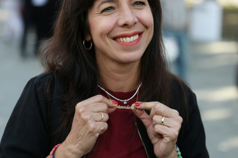 Elif Eralp, la candidate de Die Linke à Berlin, montre son pendentif sur lequel est inscrit "Mietendeckel" ("Plafonnement des loyers"), en campagne électorale le 18 septembre 2026 dans la capitale allemande   ( AFP / Odd ANDERSEN )