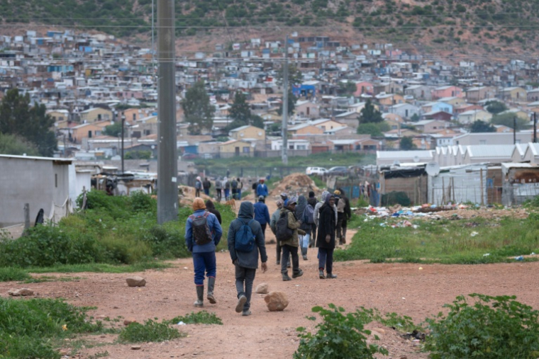Des travailleurs, pour la plupart employés dans des fermes locales, rentrent chez eux à Nkqubela, un township et campement informel de la ville de Robertson (province du Cap-Occidental, Afrique du Sud), le 9 juillet 2026 ( AFP / RODGER BOSCH )