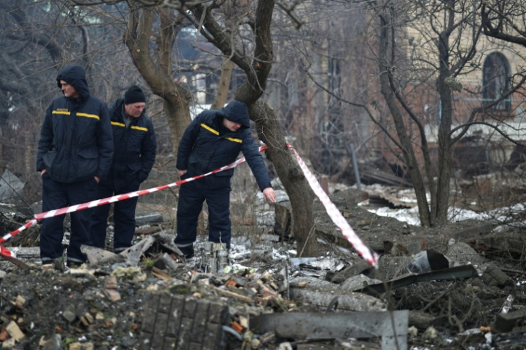 Des secouristes ukrainiens inspectent les lieux après une attaque aérienne à Sofiivska Borshchagivka, dans la région de Kiev, le 22 février 2026 ( AFP / Henry NICHOLLS )
