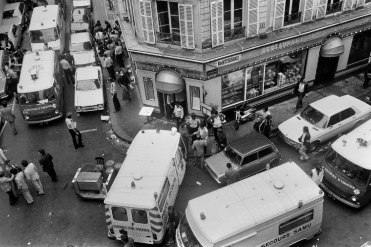 Des pompiers et des secouristes rue des Rosiers, à Paris, après que le restaurant traiteur franco-juif Jo Goldenberg a été attaqué par des hommes armés, le 9 août 1982 ( AFP / Jacques DEMARTHON )