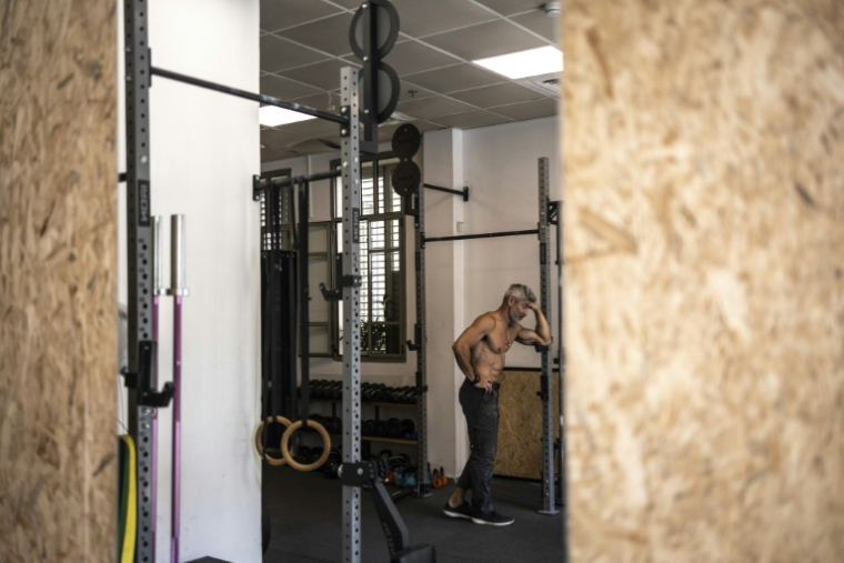 Un homme se tient debout dans sa salle de sport dans la ville côtière israélienne de Tel Aviv, le 9 mars 2026.  ( AFP / OLYMPIA DE MAISMONT )