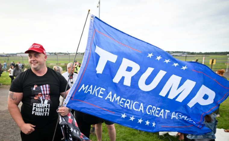 Un partisan de Donald Trump attend l'arrivée du président américain à l'aéroport de Prestwick, en Ecosse, le 25 juillet 2025 ( AFP / ANDY BUCHANAN )