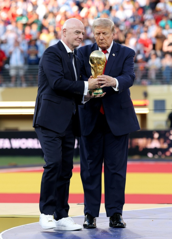 Le président de la Fifa Gianni Infantino (à gauche) et le président américain Donald Trump tiennent le trophée de la Coupe du monde 2026 avant de le remettre à l'Espagne, championne du monde le 19 juillet 2026 à East Rutherford (Etats-UNis) ( GETTY IMAGES NORTH AMERICA / Carl Recine )