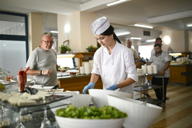 La saisonnière venue d'Ouzbékistan Gülraykhan Muxanbetovna dans les cuisines d'un hôtal de la station balnéaire d'Albena, le 17 août 2025 sur la mer Noire, en Bulgarie ( AFP / Nikolay DOYCHINOV )