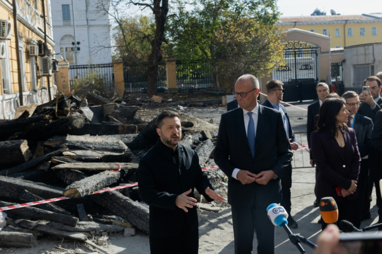Le président ukrainien Volodymyr Zelensky (G) et le chancelier allemand Friedrich Merz (D) lors d'une visite du bâtiment endommagé de l'Académie des sciences de Kiev, le 4 octobre 2026  ( AFP / Tetiana DZHAFAROVA )