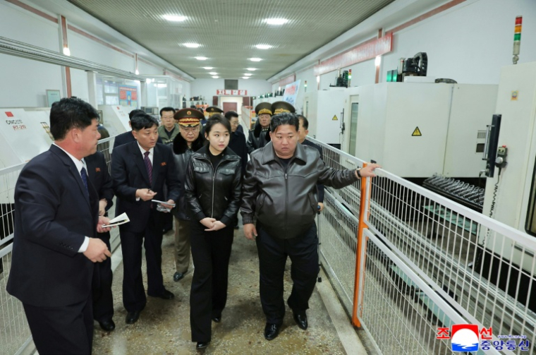 Photo prise le 11 mars 2026 et publiée par l'agence étatique de Corée du Nord KCNA le 12 mars de Kim Ju Ae et son père, le dirigeant nord-coréen Kim Jong Un, visitant une usine d'armement dans un lieu non divulgué en Corée du Nord ( KCNA VIA KNS / STR )