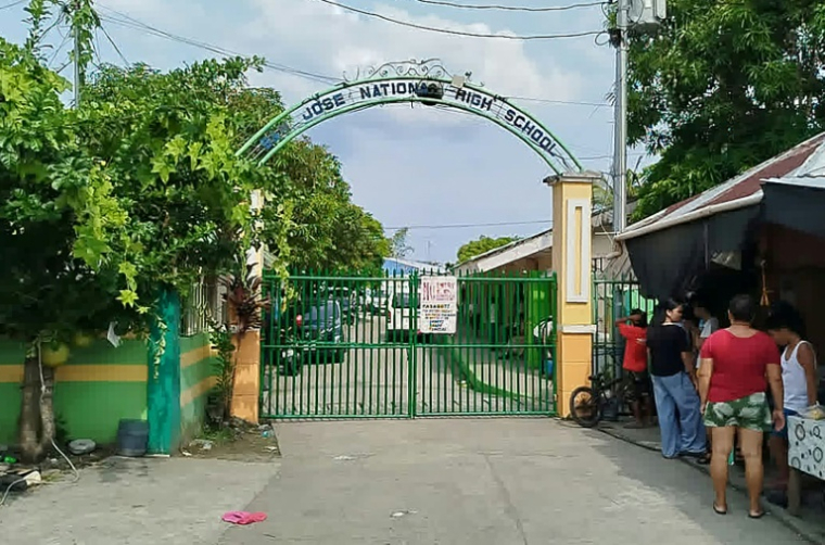 Près de l'entrée du lycée de Tacloban, aux Philippines, où une fusillade meurtrière a eu lieu, le 22 juin 2026 ( AFP / Noel  Sianosa )