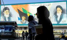 Une femme marche près d'un panneau montrant les ayatollahs Rouhollah Khomeini et Ali Khamenei, le 21 février 2026 à Téhéran ( AFP / - )