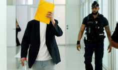 David G., un animateur périscolaire accusé d'agressions sexuelles sur des enfants d'école maternelle, cache son visage à son arrivée au tribunal de Paris, au premier jour de son procès, le 26 mai 2026 ( AFP / SIMON WOHLFAHRT )