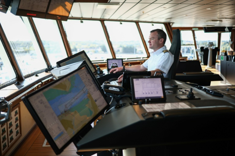 Le capitaine Will Whatley sur le pont du RRS Sir David Attenborough, amarré au port international de Harwich, dans l'est de l'Angleterre, le 6 octobre 2025, avant le départ du navire pour entreprendre des recherches dans l'Antarctique. ( AFP / HENRY NICHOLLS )