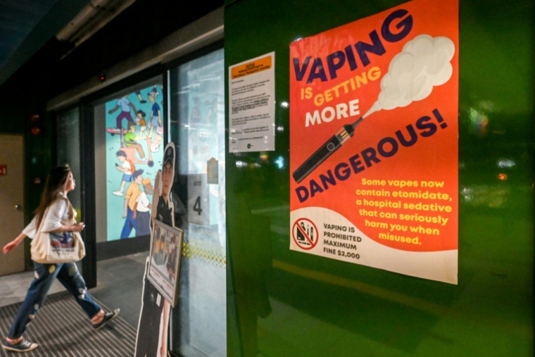 Une affiche mettant en garde contre les dangers liés à l'utilisation des cigarettes électroniques dans une gare routière à Singapour, le 17 septembre 2025 ( AFP / Roslan RAHMAN )