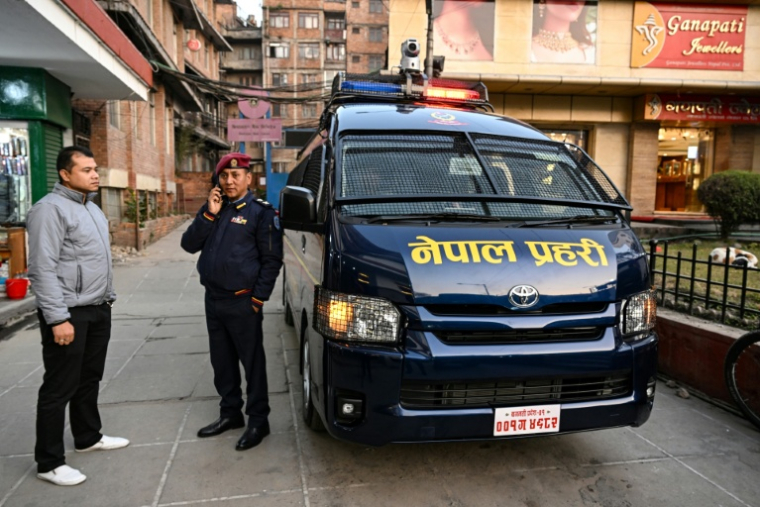 Krishna Kumar Chand, au centre, chef du poste de police de Janasewa à Katmandou, debout à côté du nouveau véhicule d’intervention rapide acquis grâce à une collecte de fonds organisée par le travailleur social Ganapati Lal Shrestha, à gauche, à Katmandou au Népal le 29 décembre 2025 ( AFP / Prakash MATHEMA )