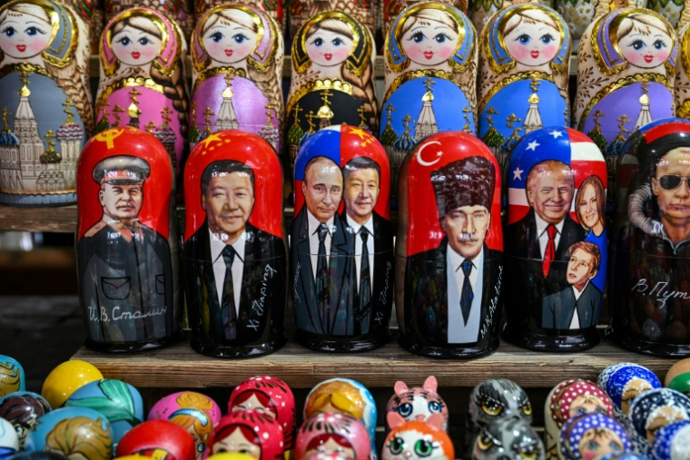 Des poupées russes en bois à l'effigie du président chinois Xi Jinping et du président russe Vladimir Poutine aiunsi que du président américain Donald Trump dans une boutique à Moscou le 10 février 2026 ( AFP / Hector RETAMAL )