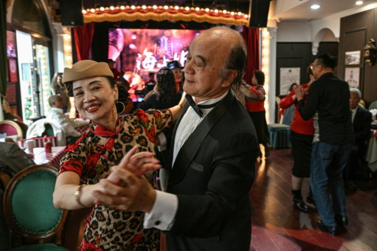 Cette photo prise le 10 décembre 2025 montre Wang Li, 65 ans, en train de danser avec un partenaire dans une salle de danse du district de Changning à Shanghai  ( AFP / Hector RETAMAL )