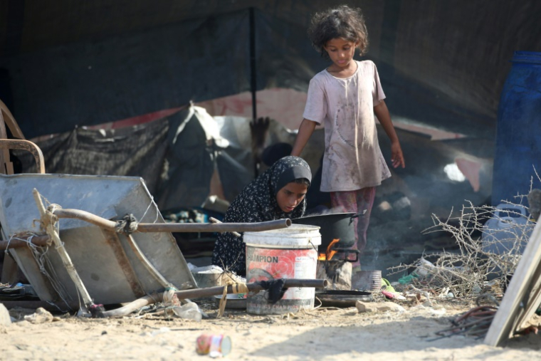 Des jeunes Palestiniennes déplacées devant une tente installée au nord-ouest du camp de réfugiés de Nousseirat, dans le centre de la bande de Gaza assiégée, le 4 octobre 2025 ( AFP / Eyad BABA )