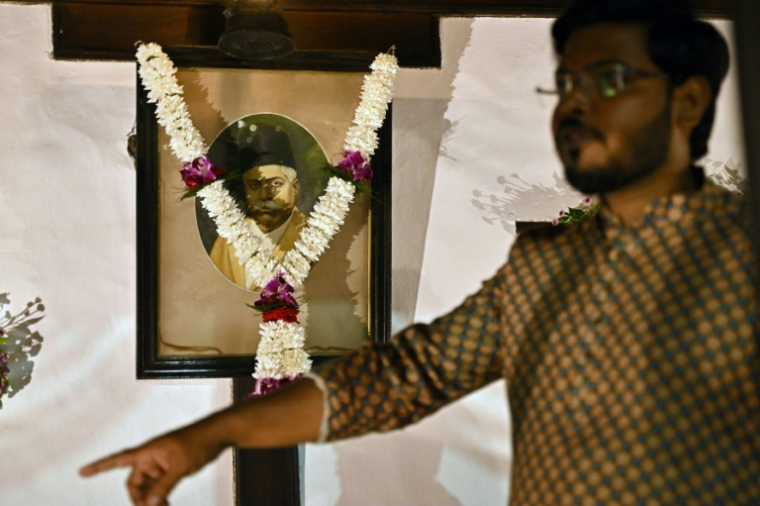 Un membre du "RSS" devant un portrait du fondateur du mouvement ultranationaliste hindou, le Dr. Keshav Baliram Hedgewar, dans sa maison de Nagpur, le 1er octobre 2025 ( AFP / Idrees MOHAMMED )