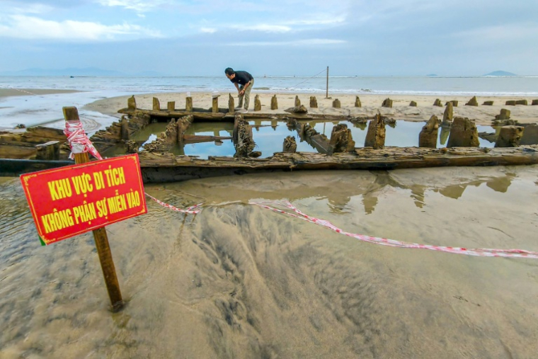 épave vieille de plusieurs siècles, découverte après le passage du typhon Kalmaegi, sur une plage au large de Hoi An, dans le centre du Vietnam, le 10 novembre 2025 ( AFP / Tam Xuan )