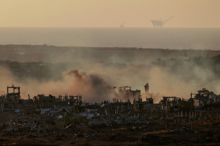 De la fumée est visible au-dessus de bâtiments détruits dans la bande de Gaza lors d'un bombardement israélien, le 21 mai 2025 ( AFP / Menahem KAHANA )