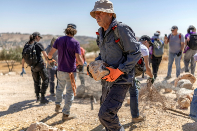 Des militants juifs pour la paix enlèvent des obstacles afin de tenter de rouvrir une route bloquée par des colons israéliens dans le village palestinien de Jannatah, en Cisjordanie occupée,  au sud de Bethléem, le 25 août 2026. ( AFP / Ilia YEFIMOVICH )