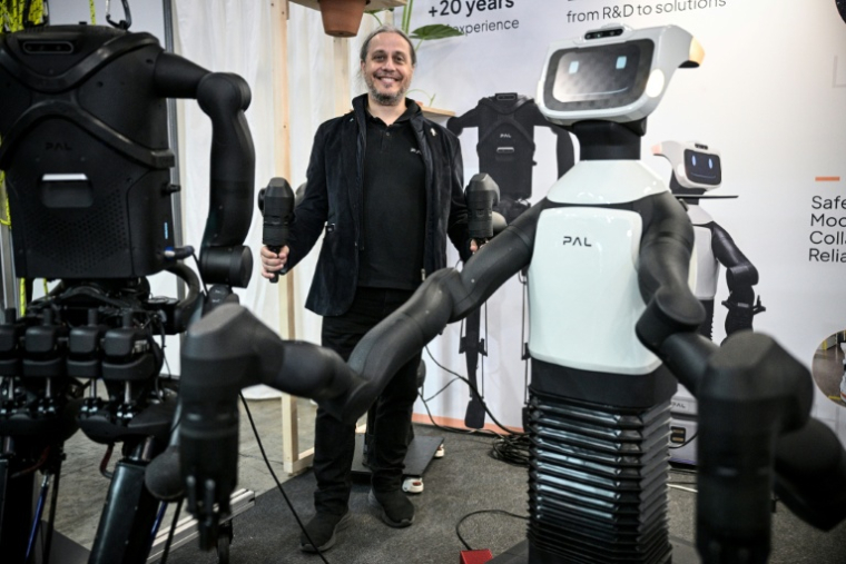 Francesco Ferro, PDG de PAL Robotics, pose aux côtés de robots lors du salon VivaTech, le 17 juin 2026 à Paris ( AFP / JULIEN DE ROSA )