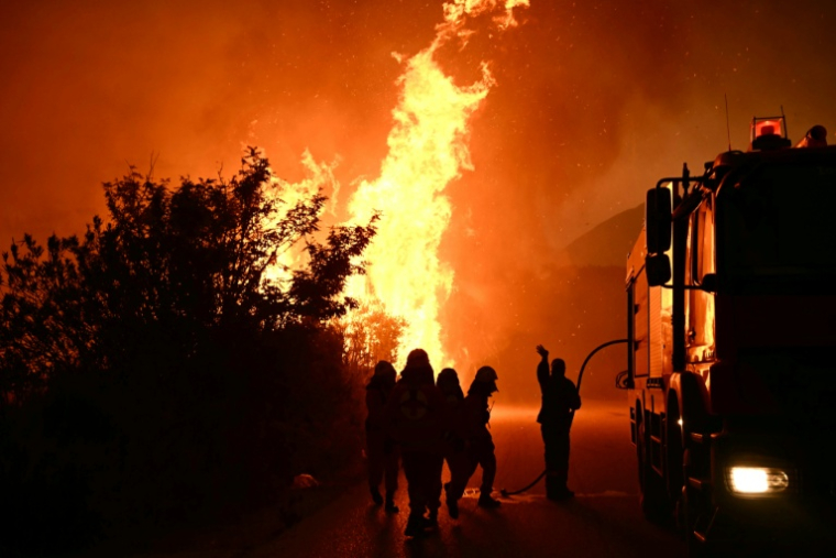 Des pompiers cherchent à éteindre un feu près de Patras, en Grèce, le 13 août 2025 ( AFP / Aris MESSINIS )