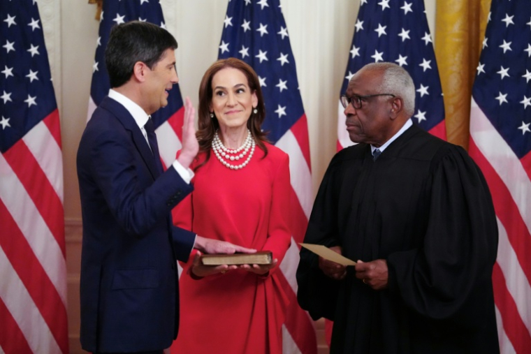 Le nouveau président de la Réserve fédérale (Fed), Kevin Warsh, accompagné de son épouse, Jane Lauder, prête serment devant le juge de la Cour suprême Clarence Thomas (d) à la Maison Blanche le 22 mai 2026 à Washington ( AFP / Aaron Schwartz )