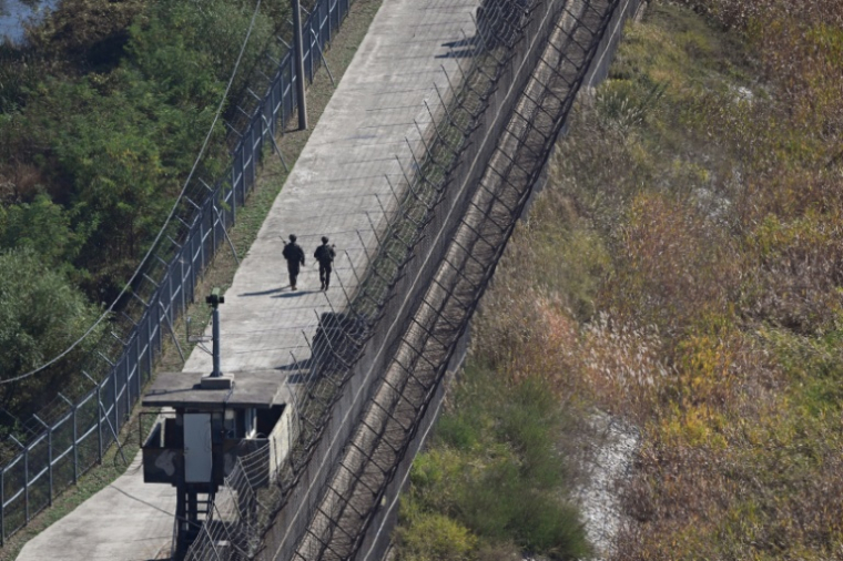 Des soldats sud-coréens patrouillent le long d’une clôture militaire, du côté sud de la zone démilitarisée (DMZ) séparant les deux Corées, vus depuis Paju, le 20 octobre 2026 en Corée du Sud ( AFP / Jung Yeon-je )
