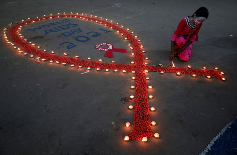 Une jeune fille allume des lampes en terre lors d'une campagne de sensibilisation au VIH/SIDA