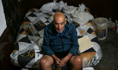 José Breijo assis sur un lit dans le couloir d'un immeuble résidentiel à Caracas, le 26 mai 2026 au Venezuela ( AFP / Juan BARRETO )