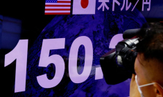 Un caméraman de télévision filme le taux de change du yen japonais par rapport au dollar américain à Tokyo