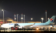 Des policiers cambodgiens et sud-coréens près de l'avion affrété pour rapatrier la soixantaine de Sud-Coréens soupçonnés d'implication dans des arnaques en ligne au Cambodge, à l'aéroport international de Techo, le 18 octobre 2025 ( AFP / TANG CHHIN Sothy )