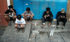 Des enfants utilisent leur smartphone à Jakarta le 26 mars 2026. ( AFP / YASUYOSHI CHIBA )
