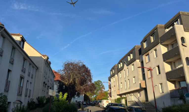 Un avion de ligne passe à basse altitude au-dessus du centre-ville de Gonesse, le 6 septembre 2025 dans le Val-d'Oise ( AFP / Antoine BOYER )