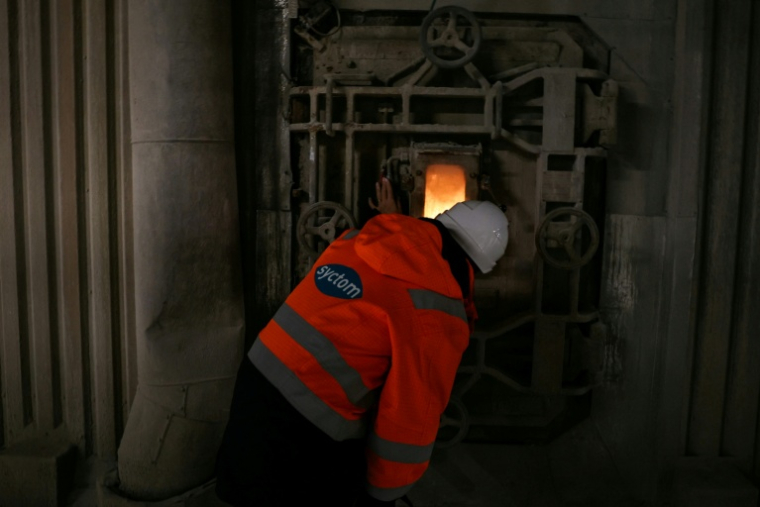 Un employé observe par une fenêtre les déchets qui brûlent dans un four de l'incinérateur Isséane Syctom d'Issy-les-Moulineaux, le 25 novembre 2025 en périphérie de Paris ( AFP / Thomas SAMSON )